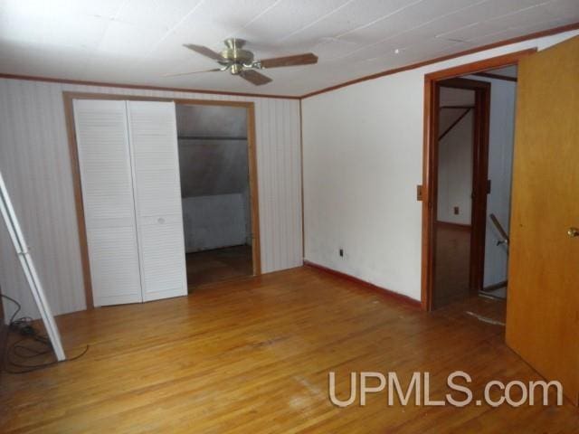 unfurnished bedroom with crown molding, ceiling fan, and hardwood / wood-style floors