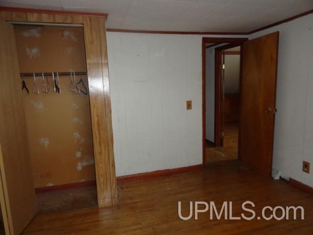 empty room featuring hardwood / wood-style flooring and ornamental molding