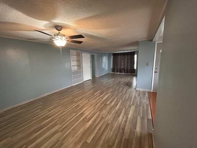 unfurnished living room with ceiling fan, a textured ceiling, and dark hardwood / wood-style flooring