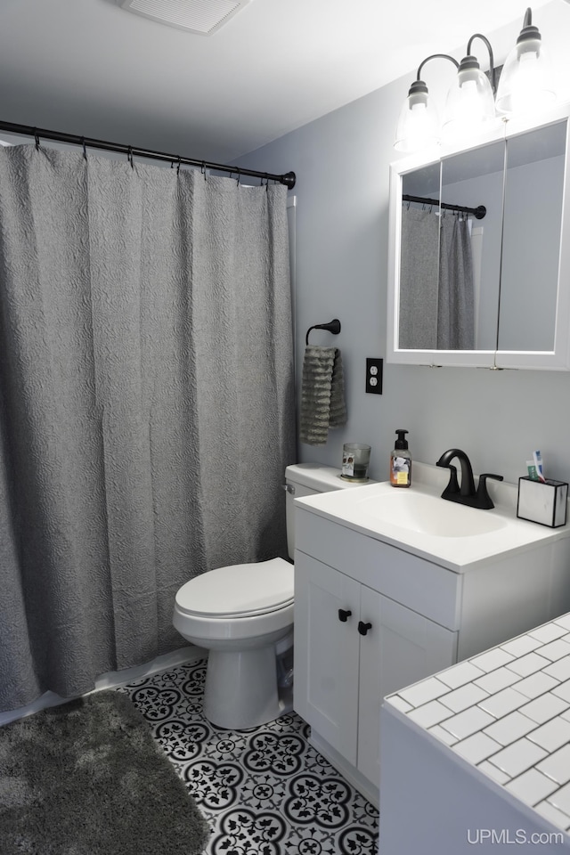 bathroom with tile patterned floors, toilet, and vanity