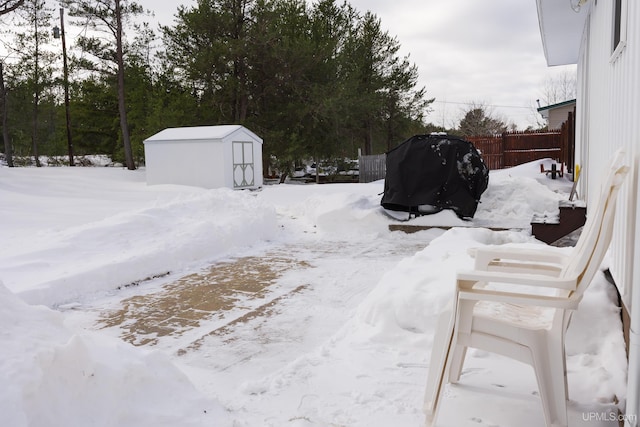 yard layered in snow featuring a shed