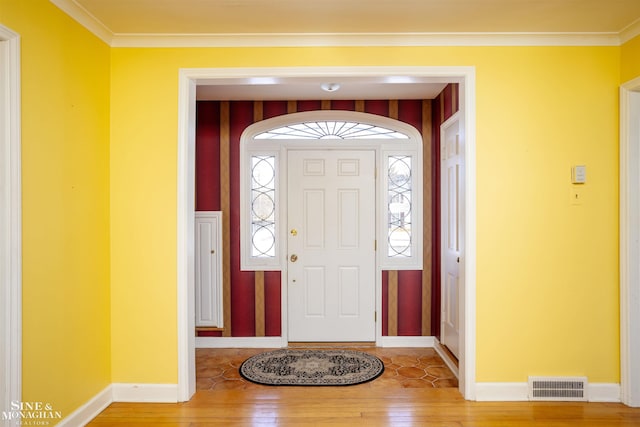 entrance foyer with ornamental molding and hardwood / wood-style floors