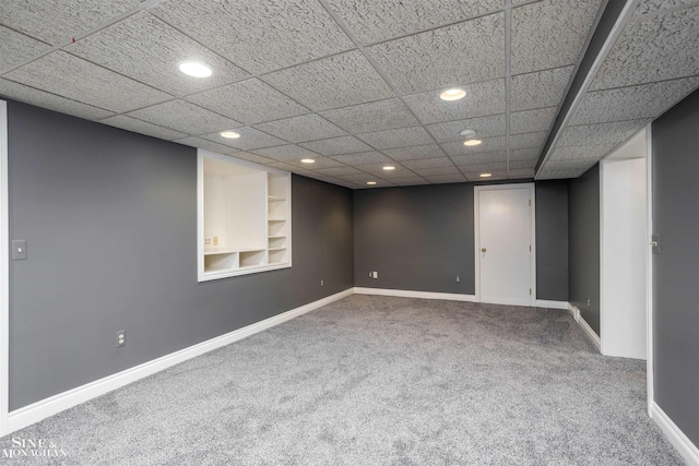 basement featuring built in shelves and carpet