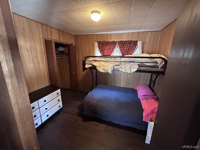 bedroom featuring dark hardwood / wood-style floors and wood walls