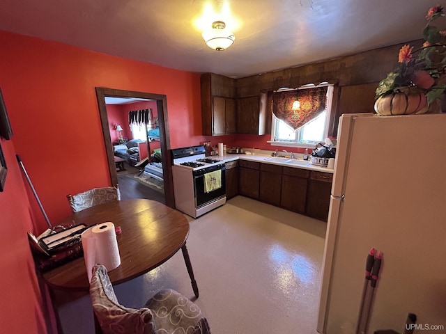 kitchen with white appliances, sink, and dark brown cabinets