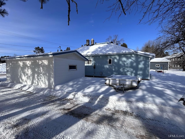 view of snow covered back of property