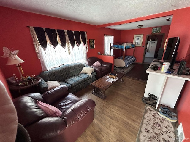 living room with hardwood / wood-style flooring and a textured ceiling