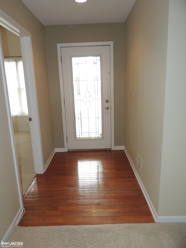 doorway to outside with baseboards, a wealth of natural light, and wood finished floors