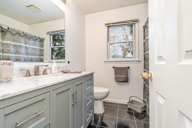 bathroom with tile patterned flooring, vanity, plenty of natural light, and toilet