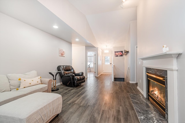 living room with lofted ceiling, dark hardwood / wood-style flooring, and a high end fireplace