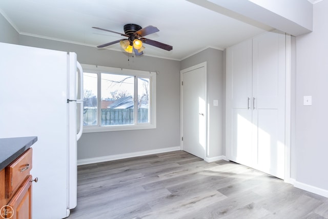 interior space featuring ornamental molding, white fridge, ceiling fan, and light wood-type flooring