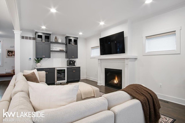 living room featuring wine cooler, crown molding, dark hardwood / wood-style flooring, and indoor bar