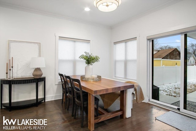 dining area with crown molding and dark hardwood / wood-style flooring