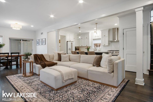 living room with decorative columns and dark hardwood / wood-style floors