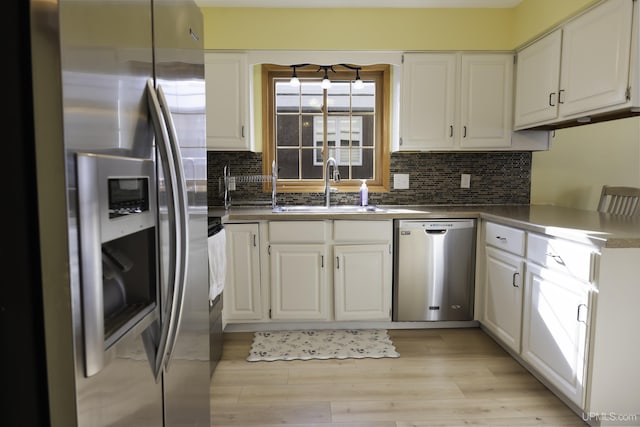 kitchen featuring white cabinetry, stainless steel appliances, sink, and light hardwood / wood-style flooring