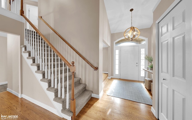 entrance foyer with an inviting chandelier, light hardwood / wood-style floors, and a high ceiling