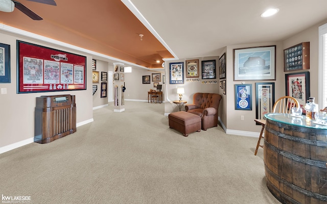 living area with carpet flooring and ceiling fan