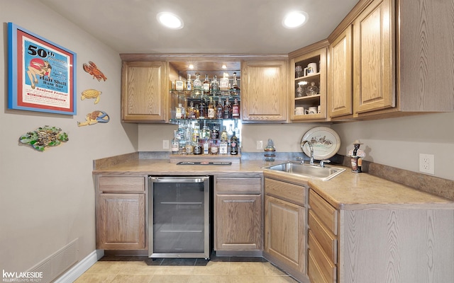 bar with light tile patterned flooring, beverage cooler, and sink