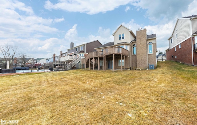 back of house with a deck with water view, a yard, and central air condition unit