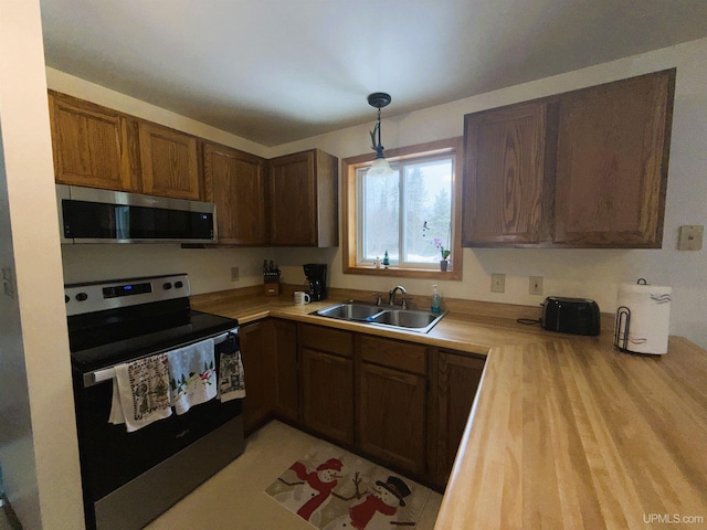 kitchen featuring stainless steel appliances, sink, and pendant lighting