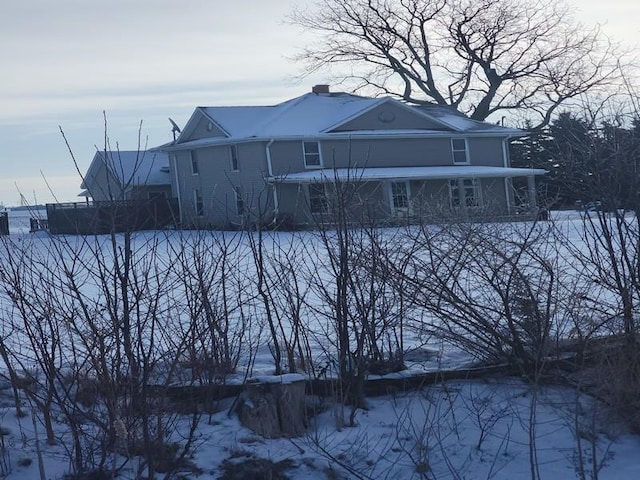 view of snow covered rear of property