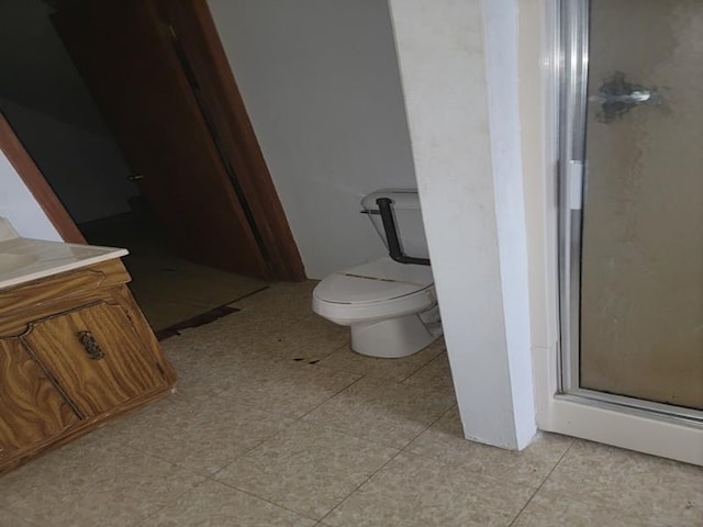 bathroom featuring an enclosed shower, vanity, tile patterned flooring, and toilet