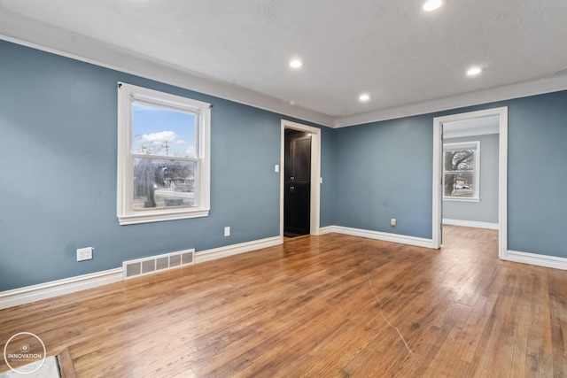 empty room featuring plenty of natural light and wood-type flooring