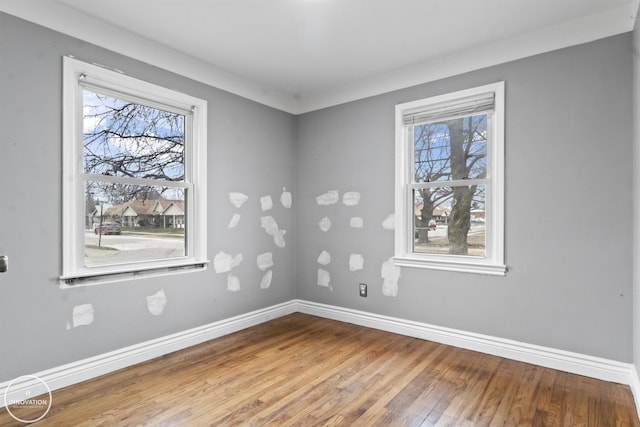 empty room with plenty of natural light and wood-type flooring