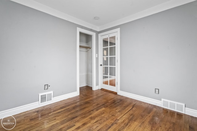 unfurnished bedroom with dark wood-type flooring and a closet