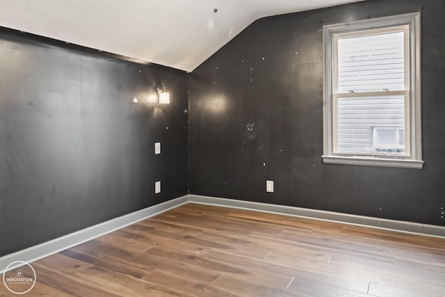 unfurnished room featuring wood-type flooring and lofted ceiling