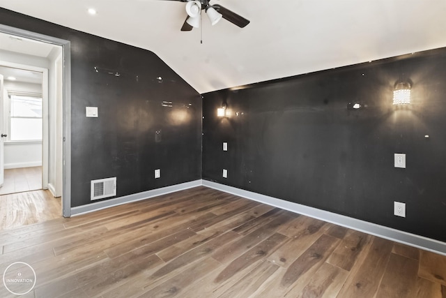 empty room featuring ceiling fan, lofted ceiling, and wood-type flooring