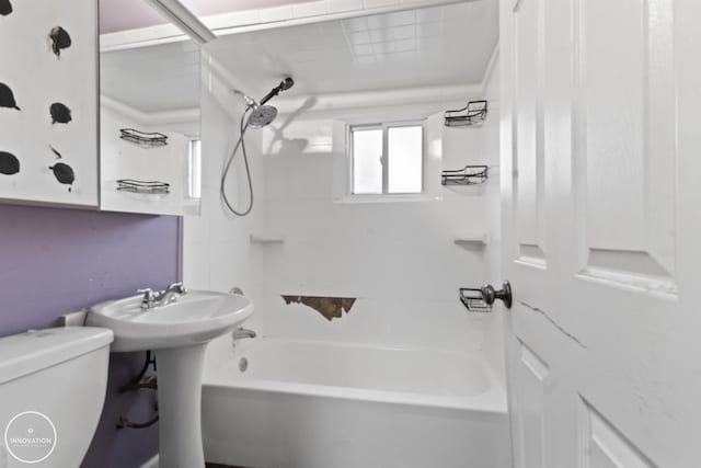 bathroom featuring tiled shower / bath combo and toilet