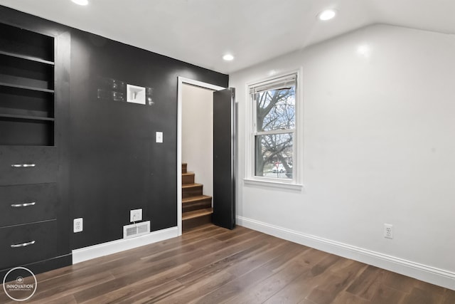 unfurnished room with dark wood-type flooring and built in shelves