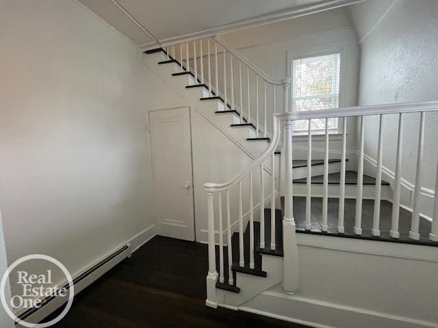 stairway with a baseboard radiator and hardwood / wood-style floors