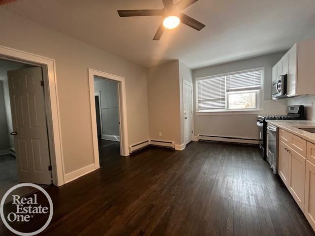 kitchen featuring stainless steel appliances, a baseboard radiator, white cabinets, and dark hardwood / wood-style flooring