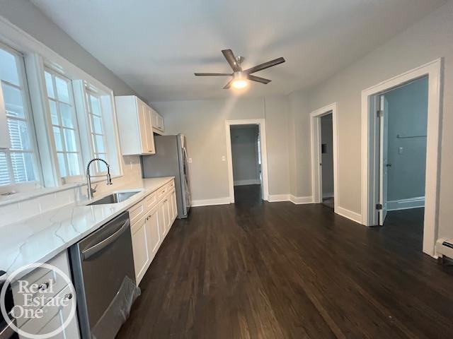 kitchen featuring white cabinetry, appliances with stainless steel finishes, sink, and light stone counters