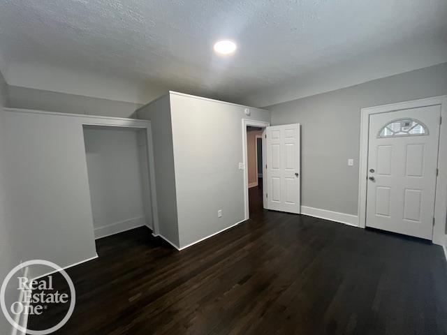 entrance foyer featuring dark hardwood / wood-style floors and a textured ceiling