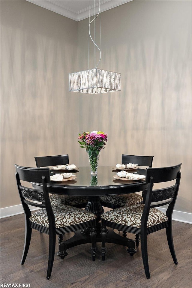 dining area featuring a notable chandelier, ornamental molding, and dark hardwood / wood-style floors