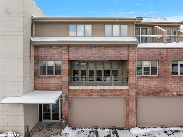 snow covered building featuring a garage