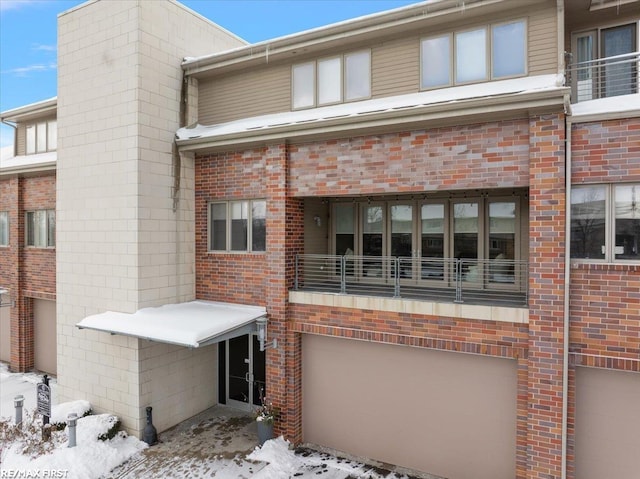 snow covered house featuring a garage