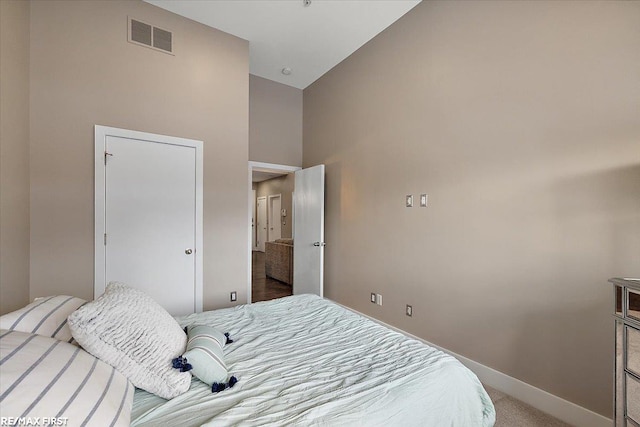 bedroom with a high ceiling and carpet floors