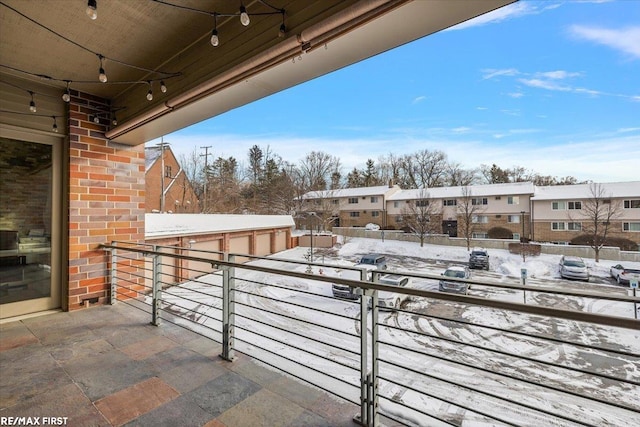 snow covered patio featuring a balcony