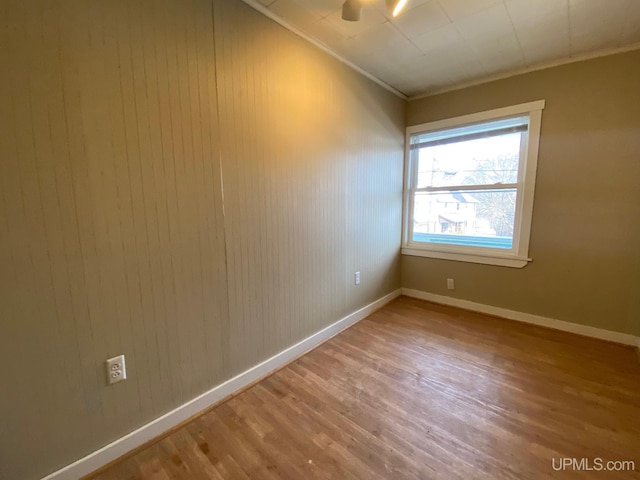 spare room with hardwood / wood-style floors and ornamental molding