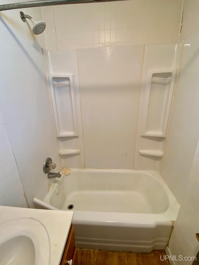 bathroom featuring shower / washtub combination, wood-type flooring, and vanity