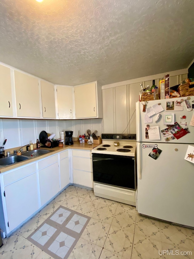 kitchen with sink, white appliances, a textured ceiling, and white cabinets