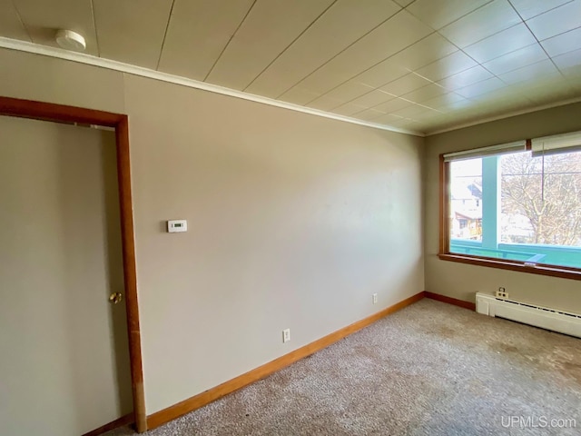 carpeted empty room with crown molding and baseboard heating