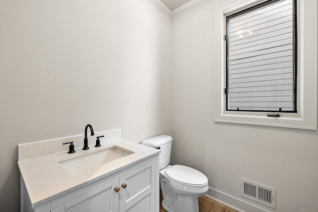 bathroom with vanity, hardwood / wood-style flooring, and toilet