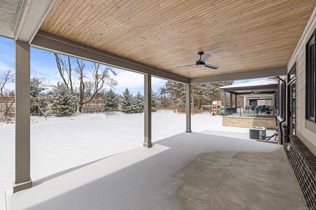 snow covered patio with ceiling fan and a playground