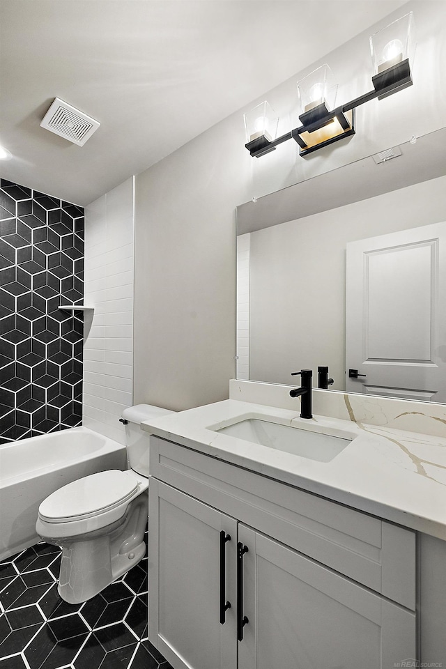 full bathroom with tile patterned floors, vanity, toilet, and tiled shower / bath combo