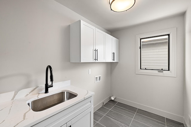 laundry area with cabinets, washer hookup, dark tile patterned flooring, and sink